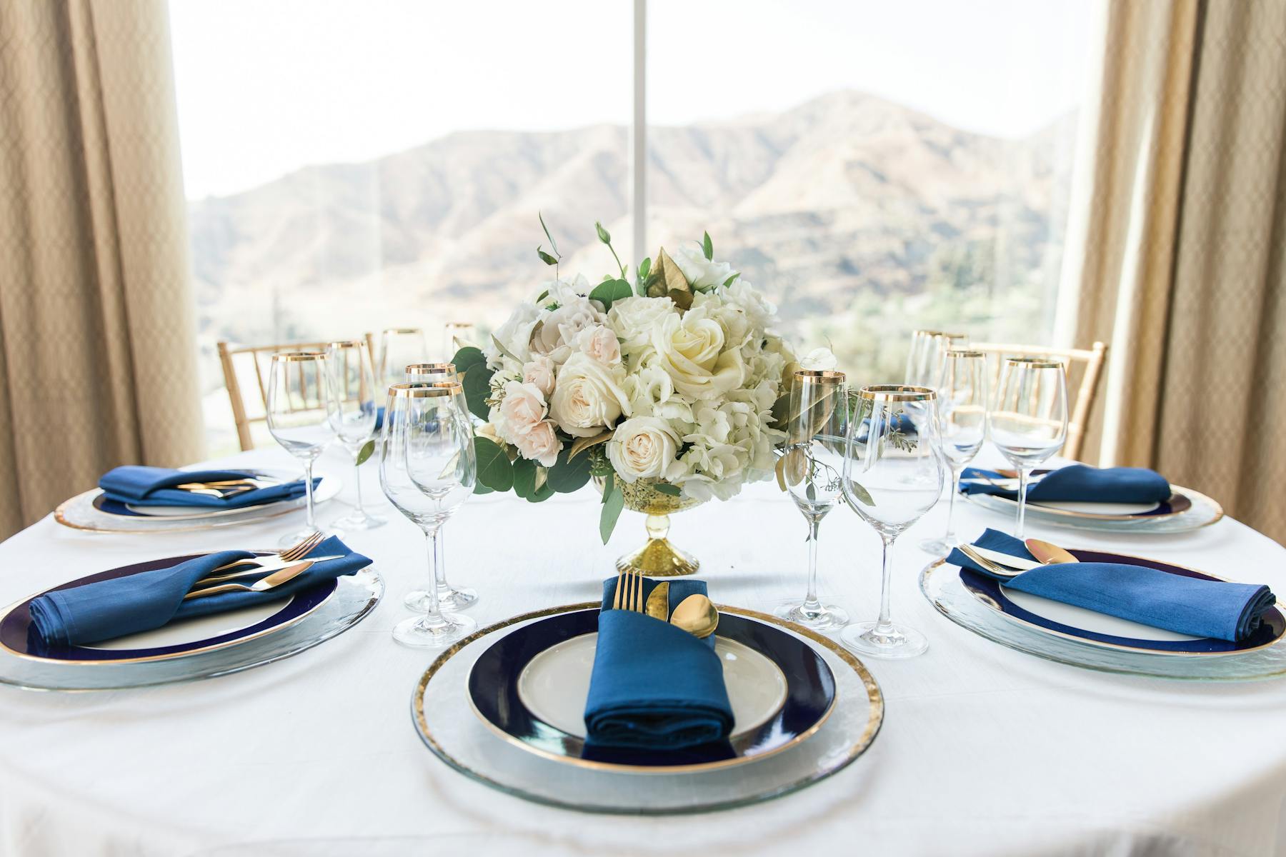 a white plate topped with a vase of flowers on a table